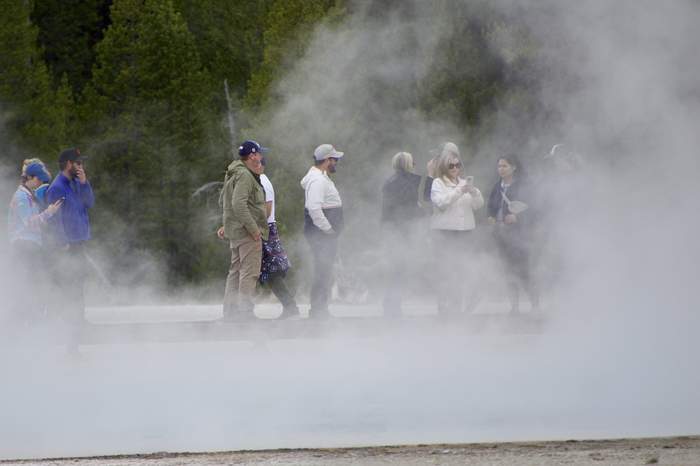 Offsite participants walking through geyser steam in Yellowstone